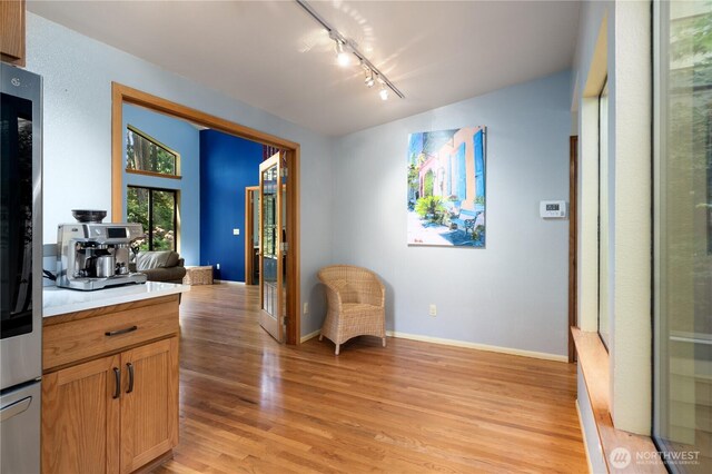 3912 Sutherland St, Gig Harbor, WA 98332 - sitting room featuring rail lighting, light wood-type flooring, and baseboards