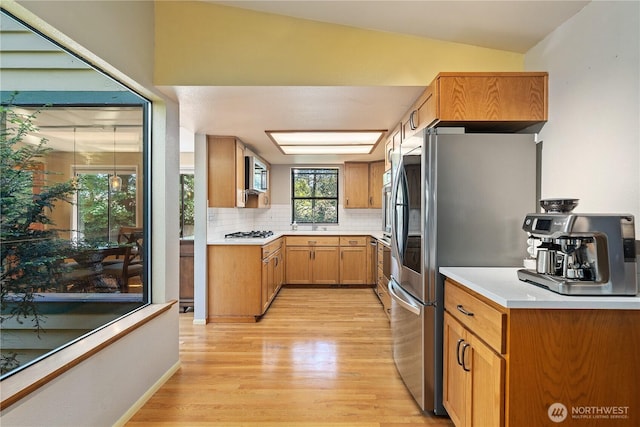 3912 Sutherland St, Gig Harbor, WA 98332 - kitchen featuring light wood-style flooring, appliances with stainless steel finishes, decorative backsplash, light countertops, and vaulted ceiling