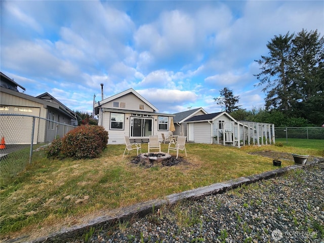 back of property with an outdoor fire pit and an outdoor structure