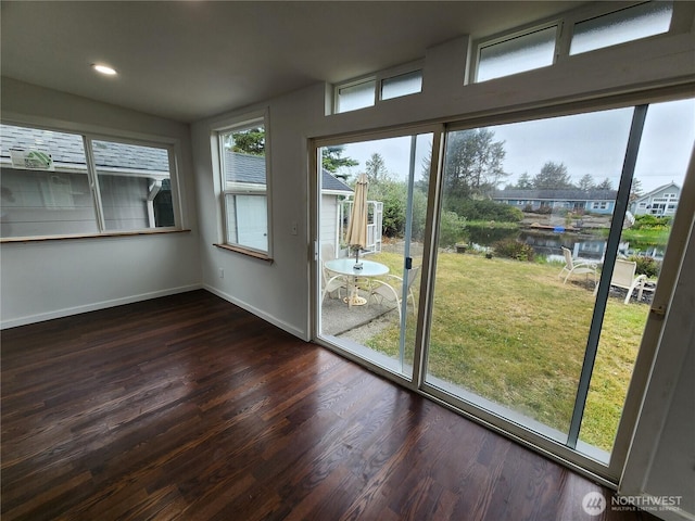 unfurnished sunroom with a water view