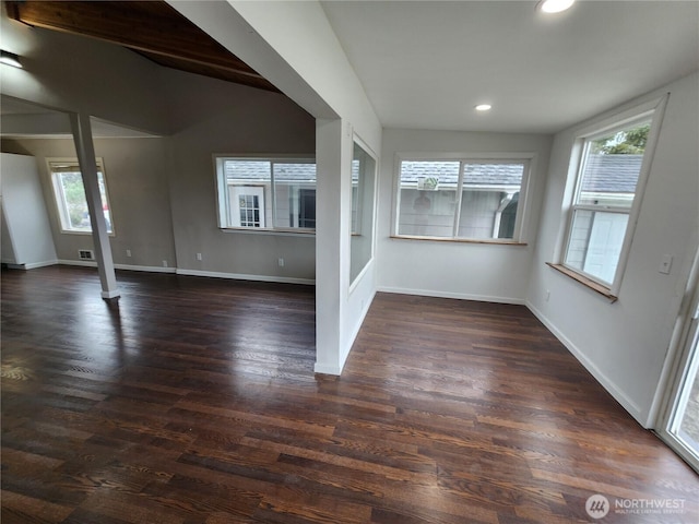 spare room featuring plenty of natural light, recessed lighting, baseboards, and dark wood-type flooring