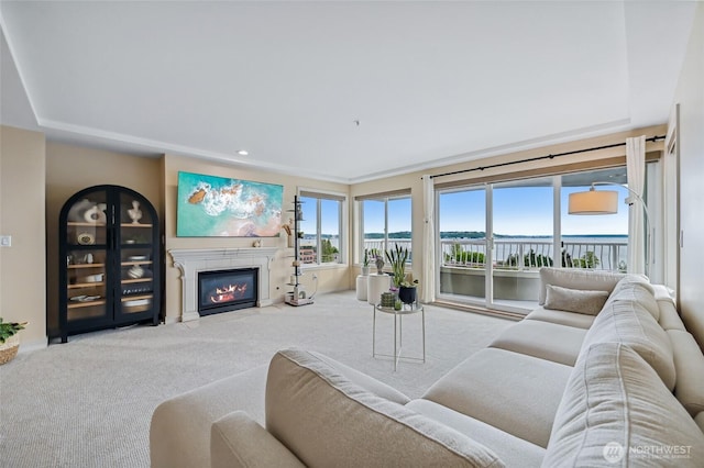 living area featuring carpet floors, a fireplace with flush hearth, and recessed lighting