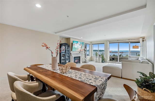 dining area with light colored carpet, a glass covered fireplace, recessed lighting, and baseboards