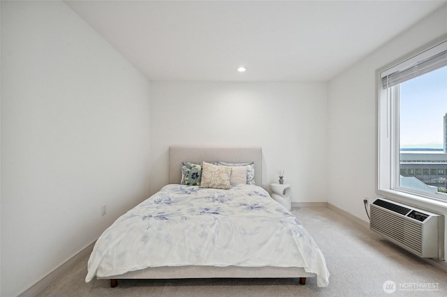 bedroom featuring light colored carpet, a wall unit AC, baseboards, and recessed lighting