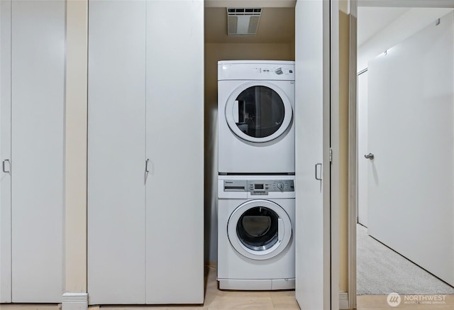 washroom featuring stacked washer / drying machine