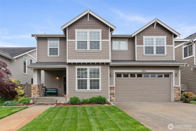 4610 204th Street Ct E, Spanaway, WA 98387 - view of front of home featuring concrete driveway, stone siding, a garage, and a front yard