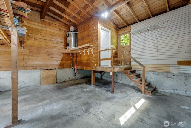 garage featuring water heater and wood walls