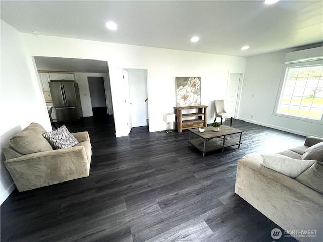 living area with a wall mounted AC, dark wood-type flooring, recessed lighting, and baseboards