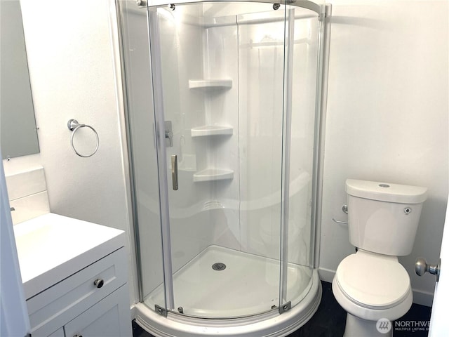 full bathroom with a shower stall, vanity, and toilet
