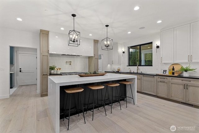 6993 N Fork Rd SE, Snoqualmie, WA 98065 - kitchen with light wood-style floors, tasteful backsplash, recessed lighting, a center island, and a sink
