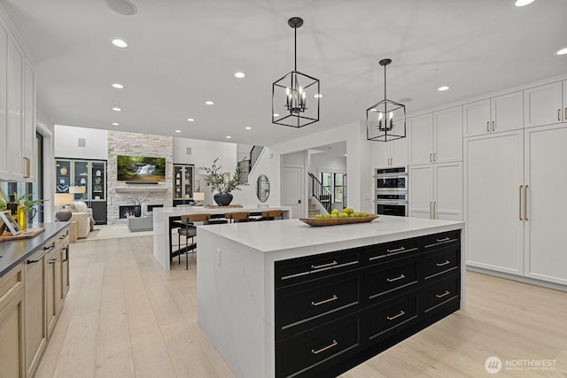 6993 N Fork Rd SE, Snoqualmie, WA 98065 - kitchen featuring dark cabinets, recessed lighting, double oven, light wood-style floors, and light countertops