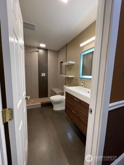 11717 93rd Ave NE Unit A7, Kirkland, WA 98034 - bathroom featuring a stall shower, toilet, vanity, and wood finished floors