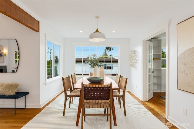 dining room featuring wood finished floors, plenty of natural light, baseboards, and recessed lighting