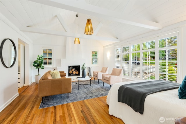 bedroom featuring wood finished floors, a brick fireplace, and baseboards