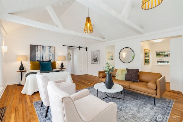 living room with a barn door, wood finished floors, and baseboards
