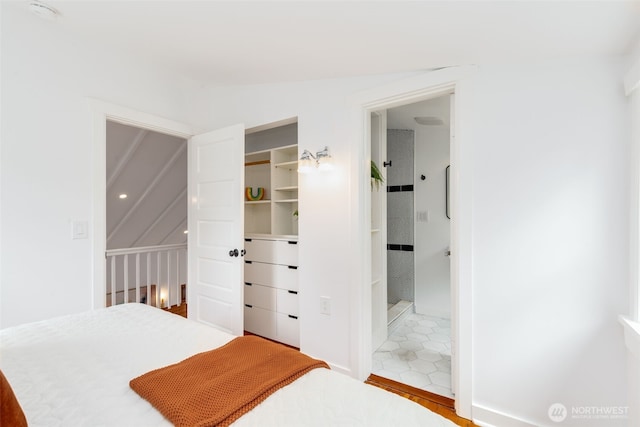bedroom with a closet, connected bathroom, and vaulted ceiling