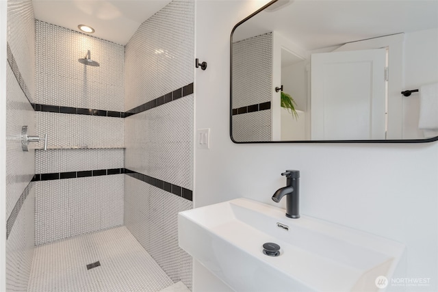 full bath with a sink and a tile shower