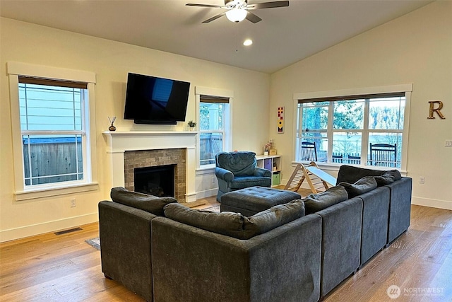 81 E Sullivan St, Allyn, WA 98524 - living room with a ceiling fan, baseboards, lofted ceiling, wood finished floors, and a brick fireplace