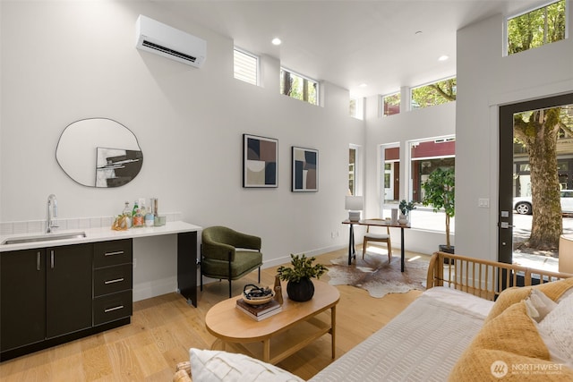 1108B 34th Ave, Seattle, WA 98122 - living area with a wall mounted air conditioner, light wood finished floors, a towering ceiling, and recessed lighting
