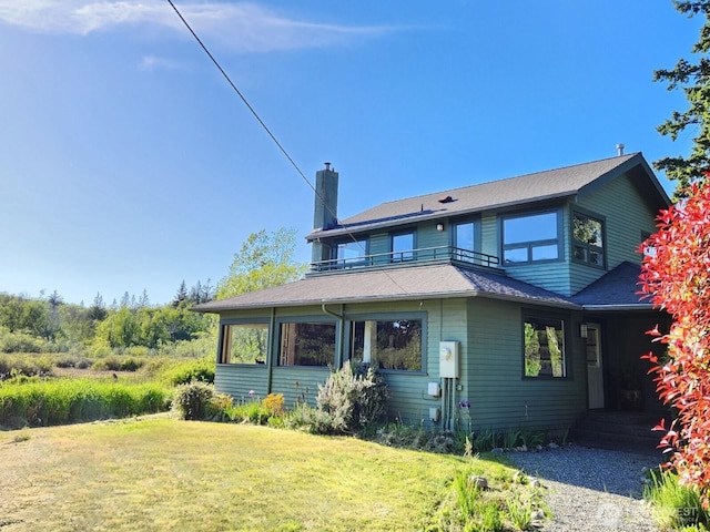 2333 Tuttle Ln, Lummi Island, WA 98262 - view of front of house featuring a balcony, a chimney, and a front yard