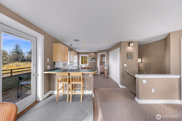 2333 Tuttle Ln, Lummi Island, WA 98262 - kitchen with carpet floors, light brown cabinets, a kitchen bar, a peninsula, and recessed lighting