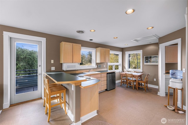 2333 Tuttle Ln, Lummi Island, WA 98262 - kitchen with light brown cabinets, white microwave, stainless steel dishwasher, a breakfast bar area, and recessed lighting