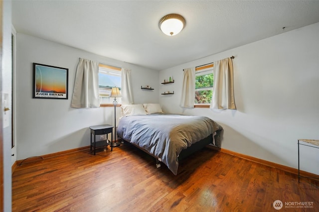 bedroom featuring wood finished floors and baseboards