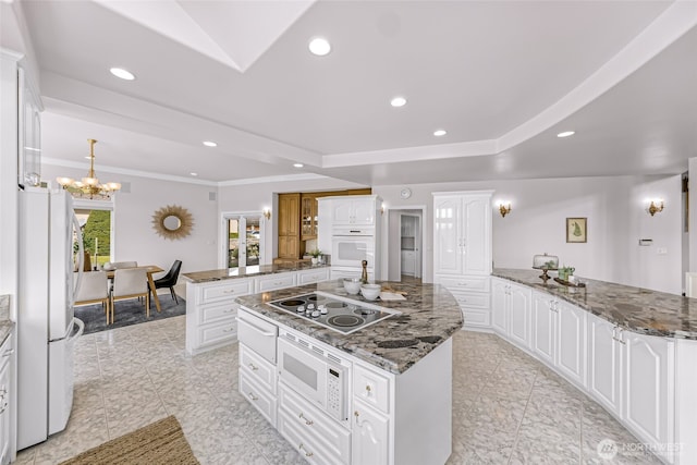 325 Island Green Way, Lynden, WA 98264 - kitchen featuring white appliances, a peninsula, a kitchen island, a chandelier, and white cabinets