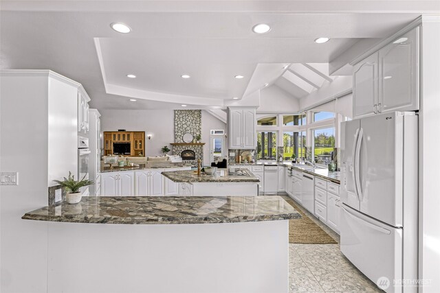 325 Island Green Way, Lynden, WA 98264 - kitchen with white refrigerator with ice dispenser, a peninsula, dishwashing machine, white cabinets, and dark stone countertops