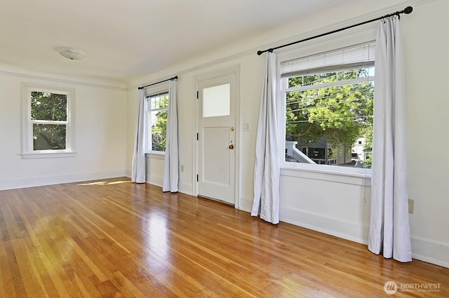 doorway to outside featuring light wood finished floors and baseboards