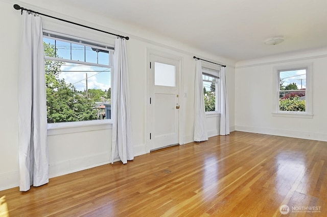 foyer entrance with light wood-style floors and baseboards