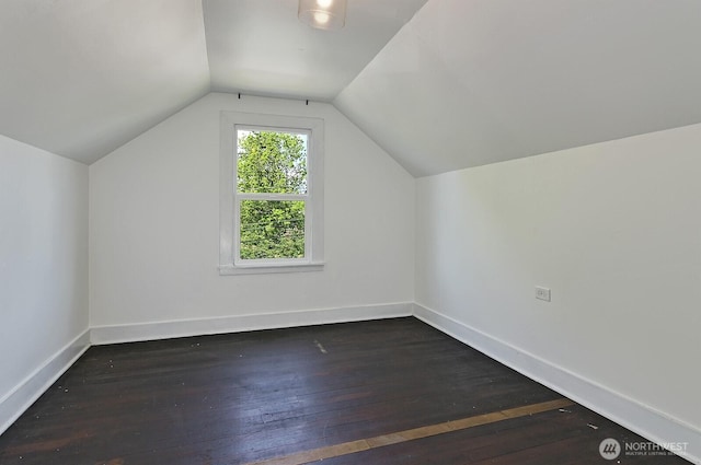 bonus room featuring dark wood-style flooring, vaulted ceiling, and baseboards