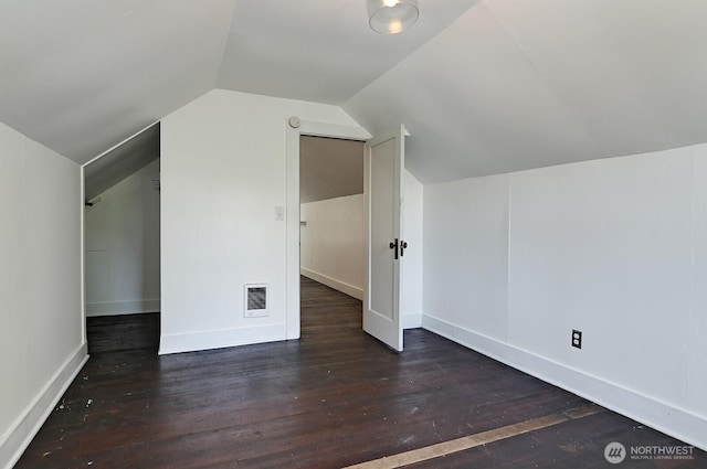 additional living space with vaulted ceiling, wood finished floors, and baseboards