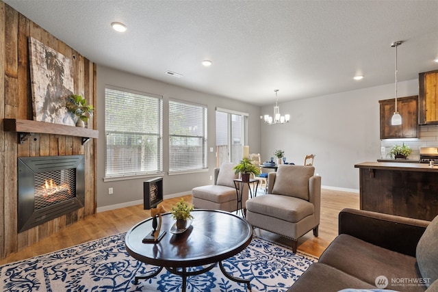 12313 NE 116th St N, Vancouver, WA 98682 - living room featuring light wood finished floors, a chandelier, a tiled fireplace, heating unit, and baseboards