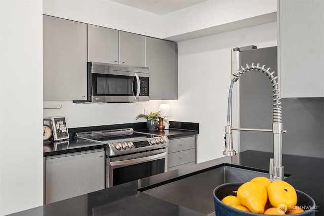 1125 E Olive St Unit 501, Seattle, WA 98122 - kitchen with stainless steel appliances, dark countertops, gray cabinetry, and a sink