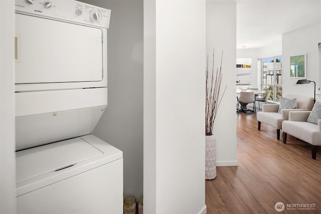 1125 E Olive St Unit 501, Seattle, WA 98122 - clothes washing area featuring estacked washer and dryer and wood finished floors