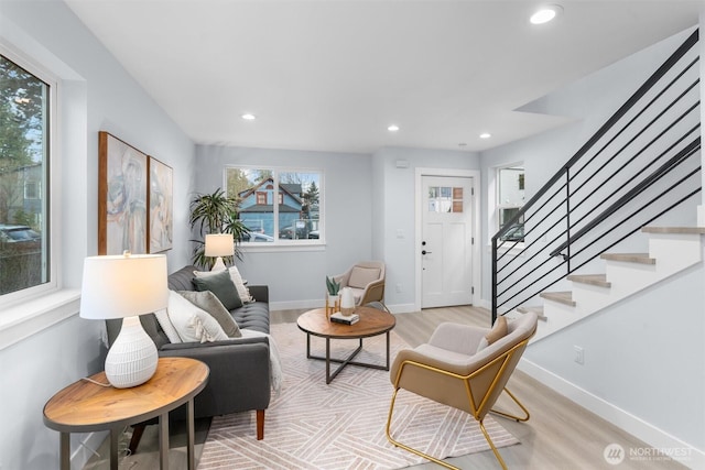 living area featuring stairs, recessed lighting, light wood-style flooring, and baseboards