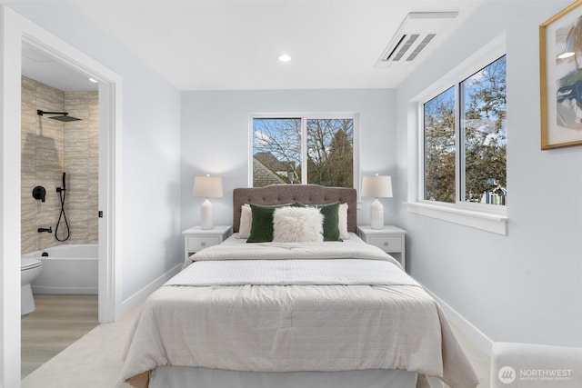 bedroom with multiple windows, baseboards, wood finished floors, recessed lighting, and ensuite bath