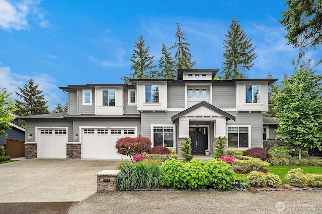 view of front of house featuring concrete driveway, stone siding, and a garage