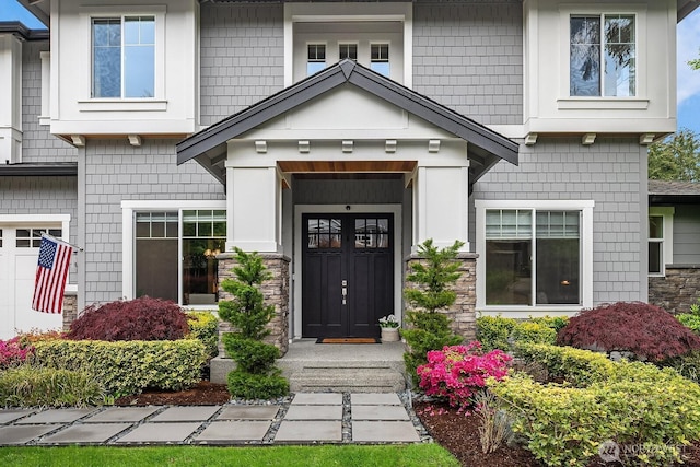 entrance to property with stone siding and a garage