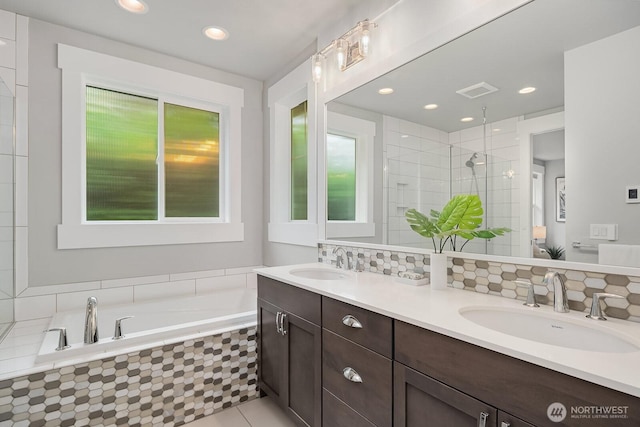 bathroom with a bath, tiled shower, double vanity, decorative backsplash, and recessed lighting