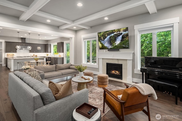 living room with dark wood finished floors, beam ceiling, recessed lighting, a premium fireplace, and coffered ceiling