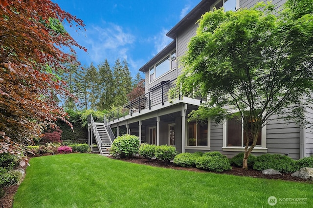 rear view of house featuring stairway, a yard, and a wooden deck