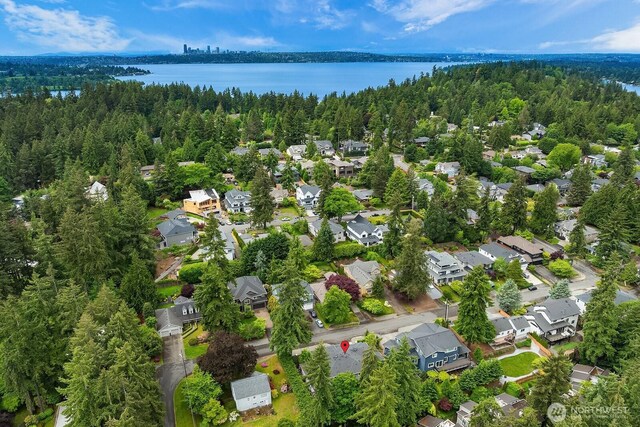 aerial view of residential area with a nearby body of water and a forest