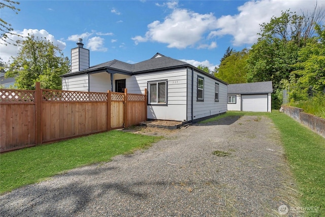 337 100th St S, Tacoma, WA 98444 - view of front of house featuring fence, gravel driveway, a chimney, and an outdoor structure