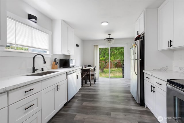 337 100th St S, Tacoma, WA 98444 - kitchen featuring appliances with stainless steel finishes, a sink, white cabinetry, dark wood-style floors, and light stone counters