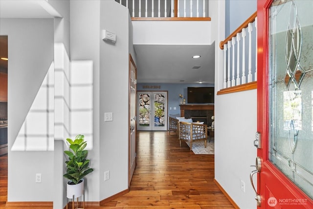 foyer entrance with hardwood / wood-style flooring, a fireplace, recessed lighting, and baseboards