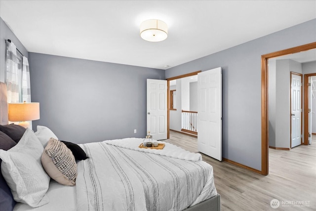 bedroom featuring light wood-style floors and baseboards