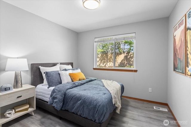 bedroom featuring wood finished floors and baseboards