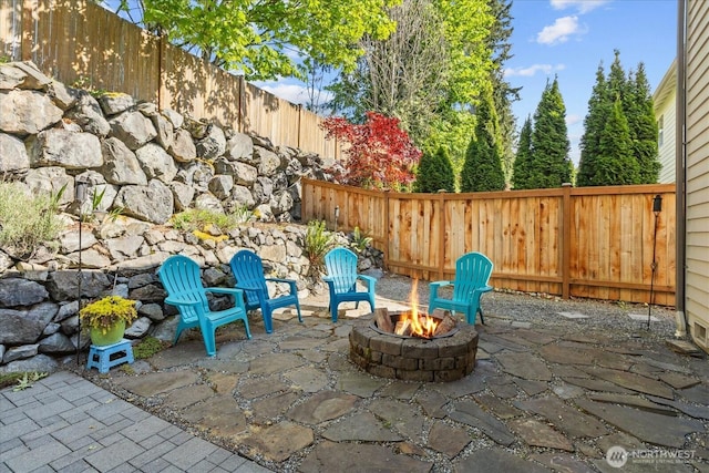 view of patio featuring an outdoor fire pit and a fenced backyard